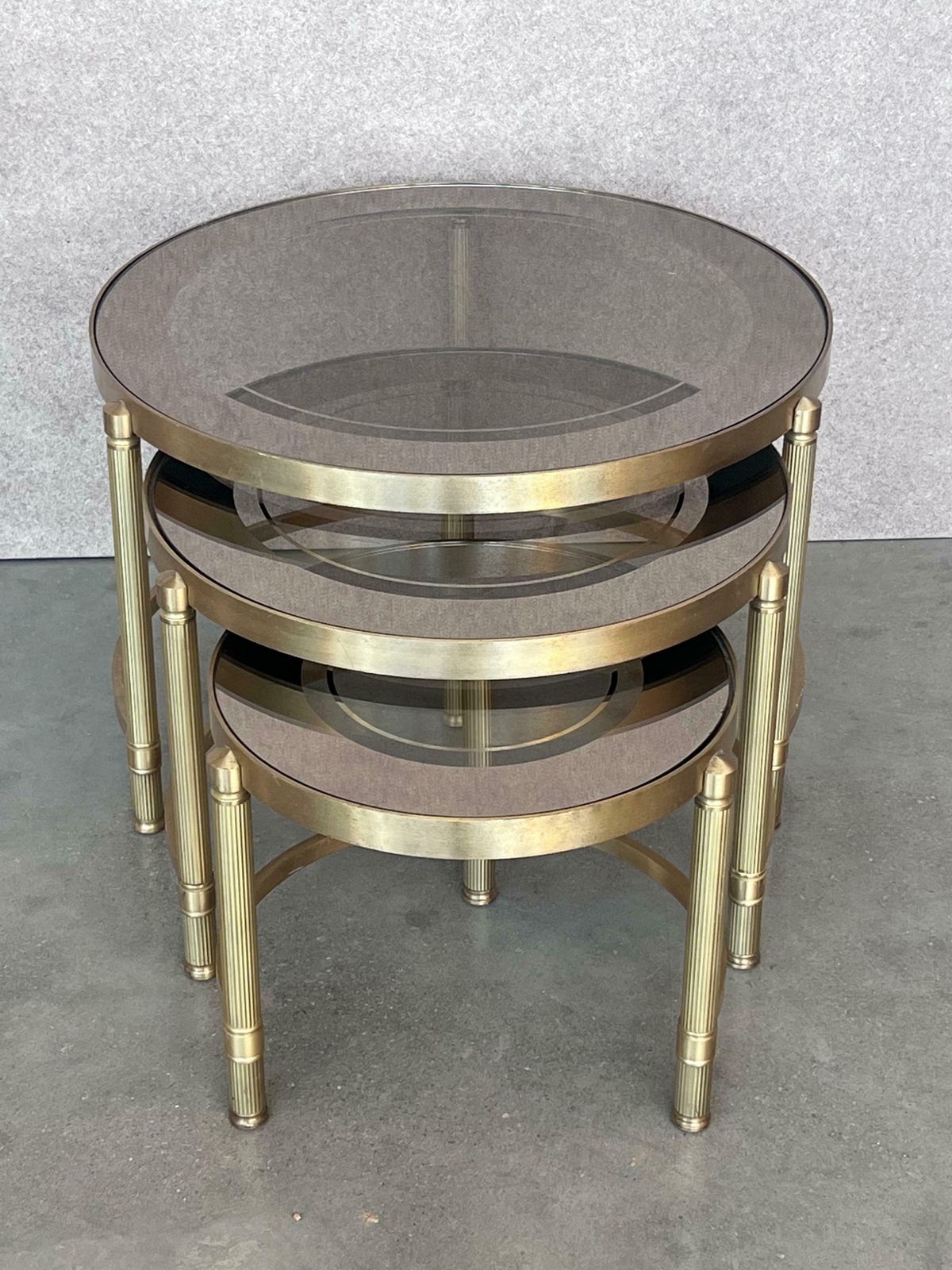 Ensemble de trois tables gigognes rondes en laiton, plateaux en verre fumé rose photo furniture