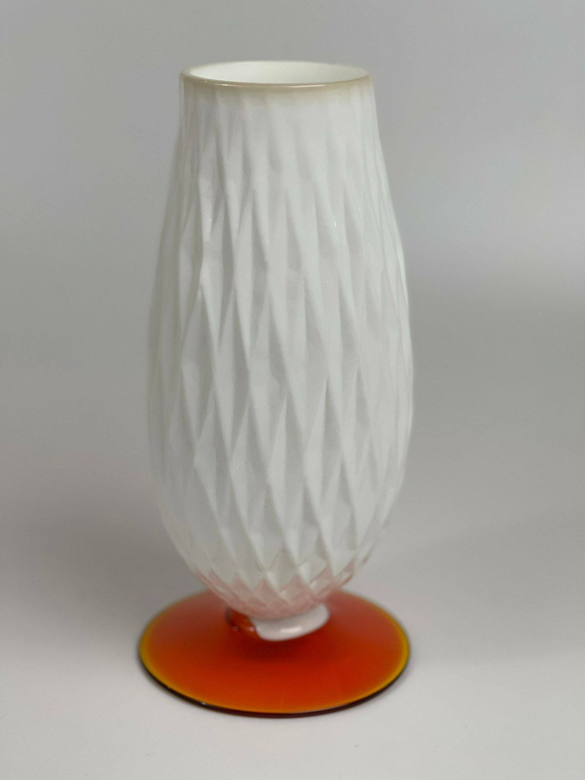 photo furniture Opaline "Milky" Glass Vase In Japanese Style With Diamond Pattern. Footed On Orange Glass Base.