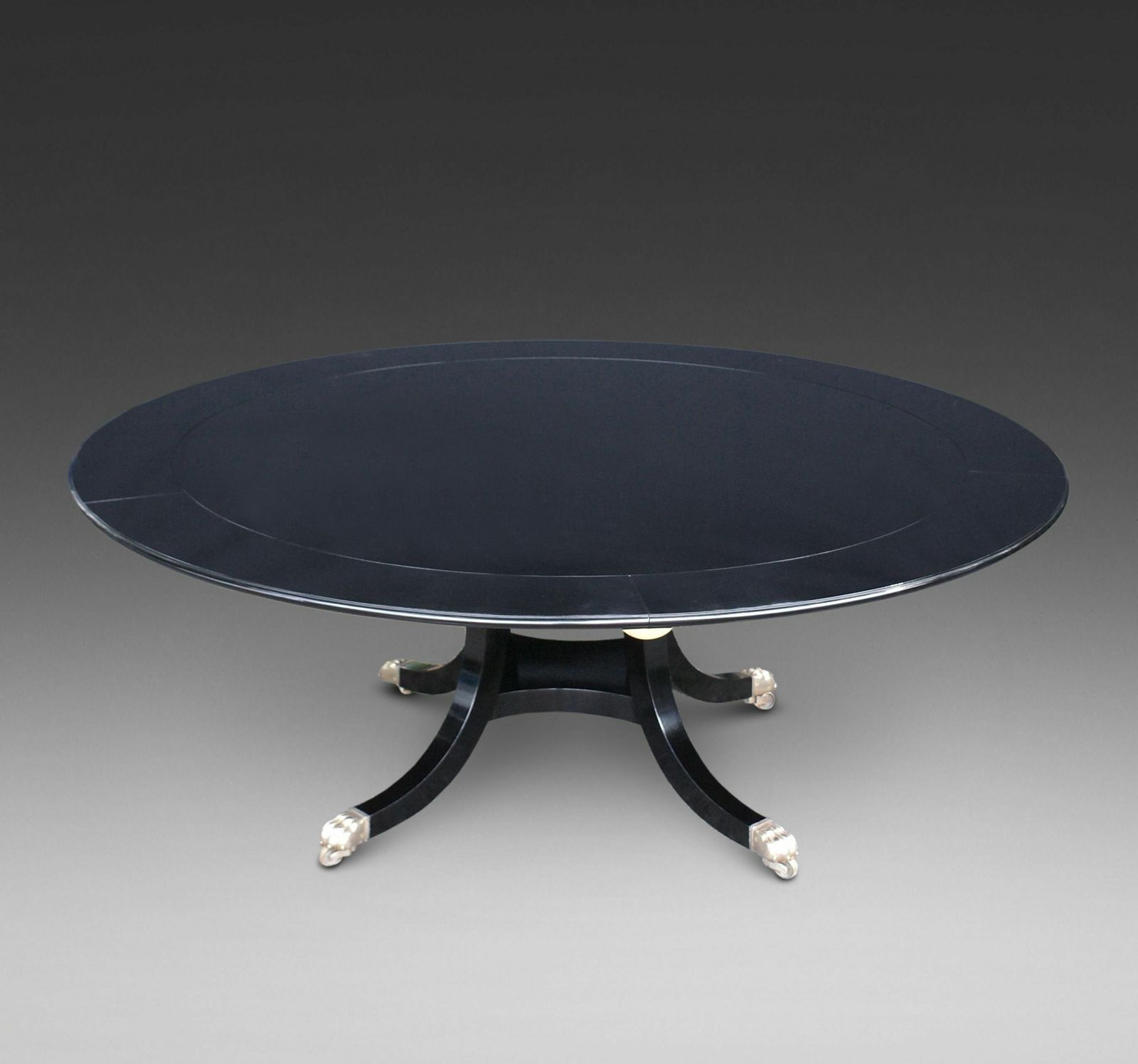 A Superb Ebonised "Jupe" Style Dining Table.