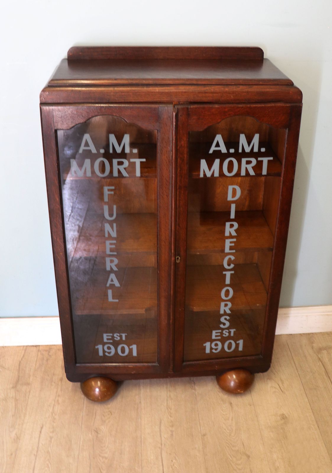 A Lovely Art Deco Styled Cabinet Sign Written With The Details Of A Funeral Directors. photo furniture