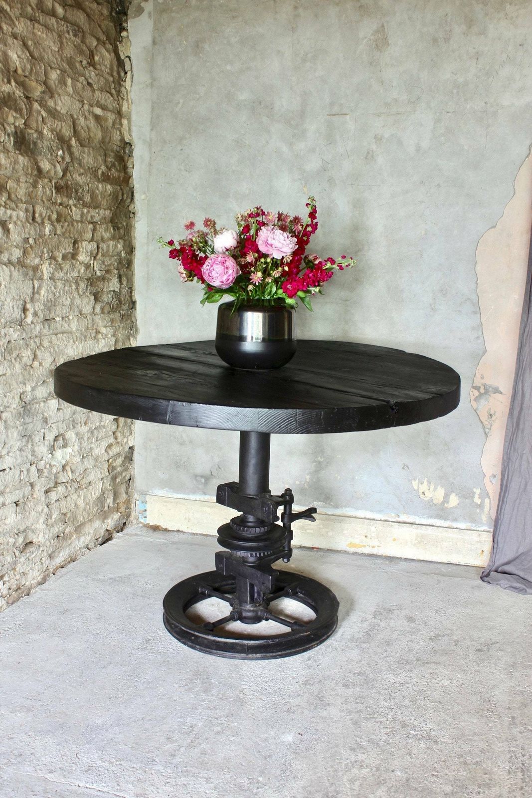 Shift Reclaimed Chunky Scorched Timber Circular Table With A Heavy Pedestal Base Made Out Of An Old Gear System