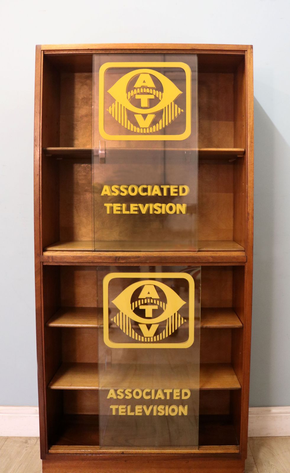 A Lovely Mid Century Display Cabinet Later Sign Written With The Emblems And Wording For Associated Television. photo furniture