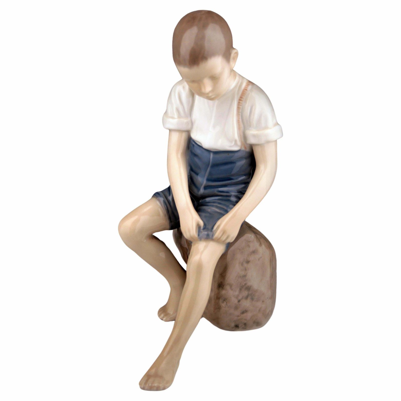 Mid 20th Century Scandinavian Modern Glazed Porcelain Sculpture Of A Boy Sitting On A Rock By Danish Company Bing & Grøndahl