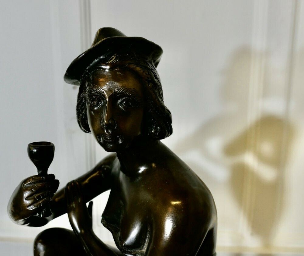 Bronze Statue Of A Girl On A Stool Drinking Champaign photo 420.0
