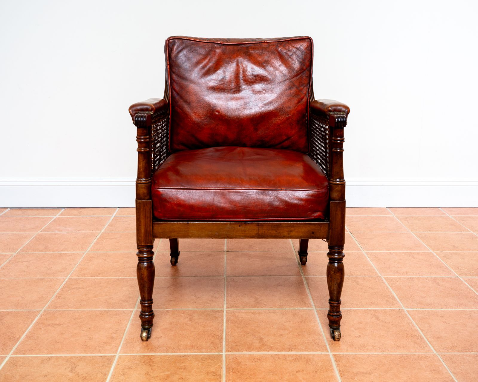 Fine Regency Bergere Leather Library Chair 1810 1820 Georgian Reading Red Leather Armchair Carved Cane Rattan Brass Castors photo for sale