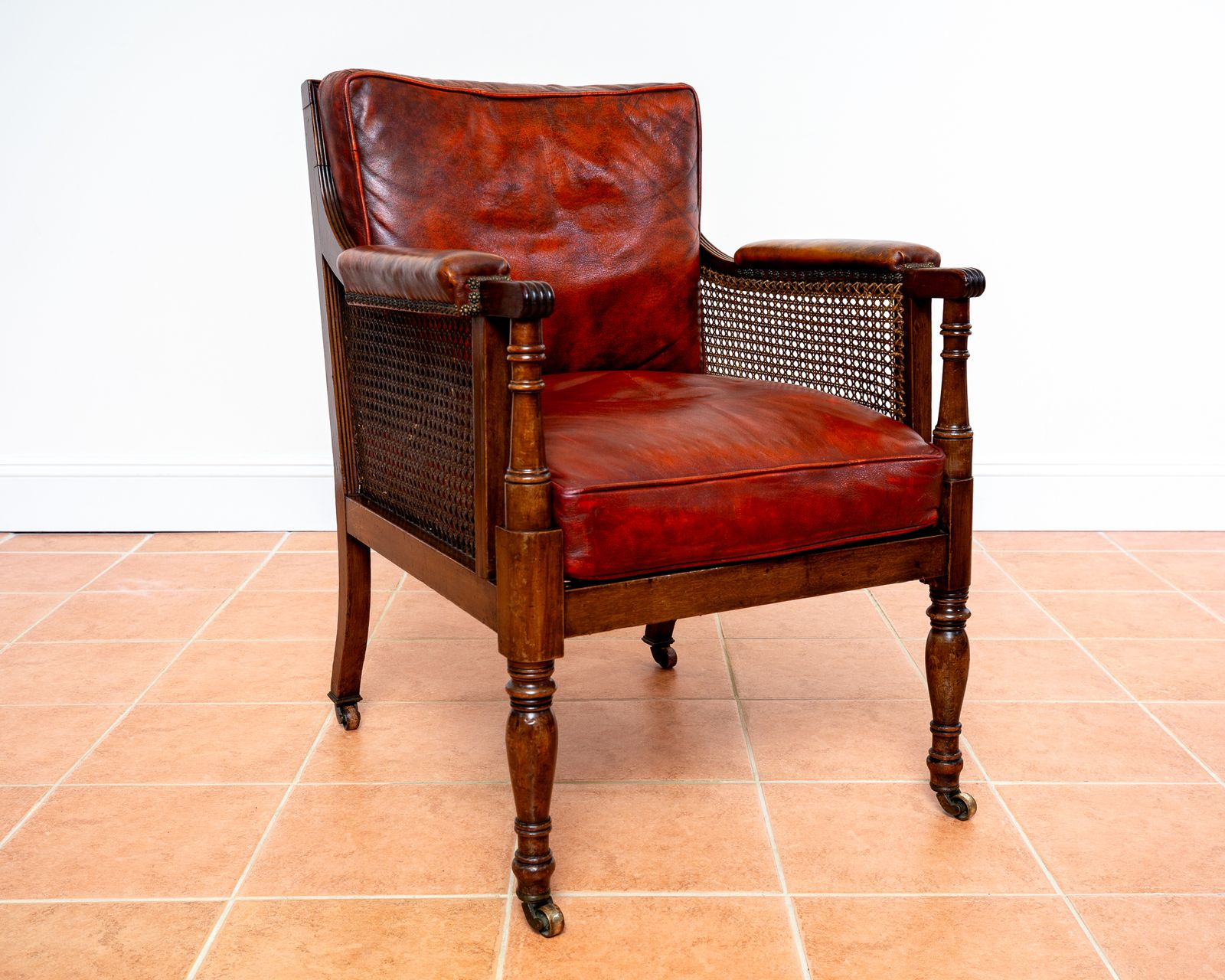 Fine Regency Bergere Leather Library Chair 1810 1820 Georgian Reading Red Leather Armchair Carved Cane Rattan Brass Castors