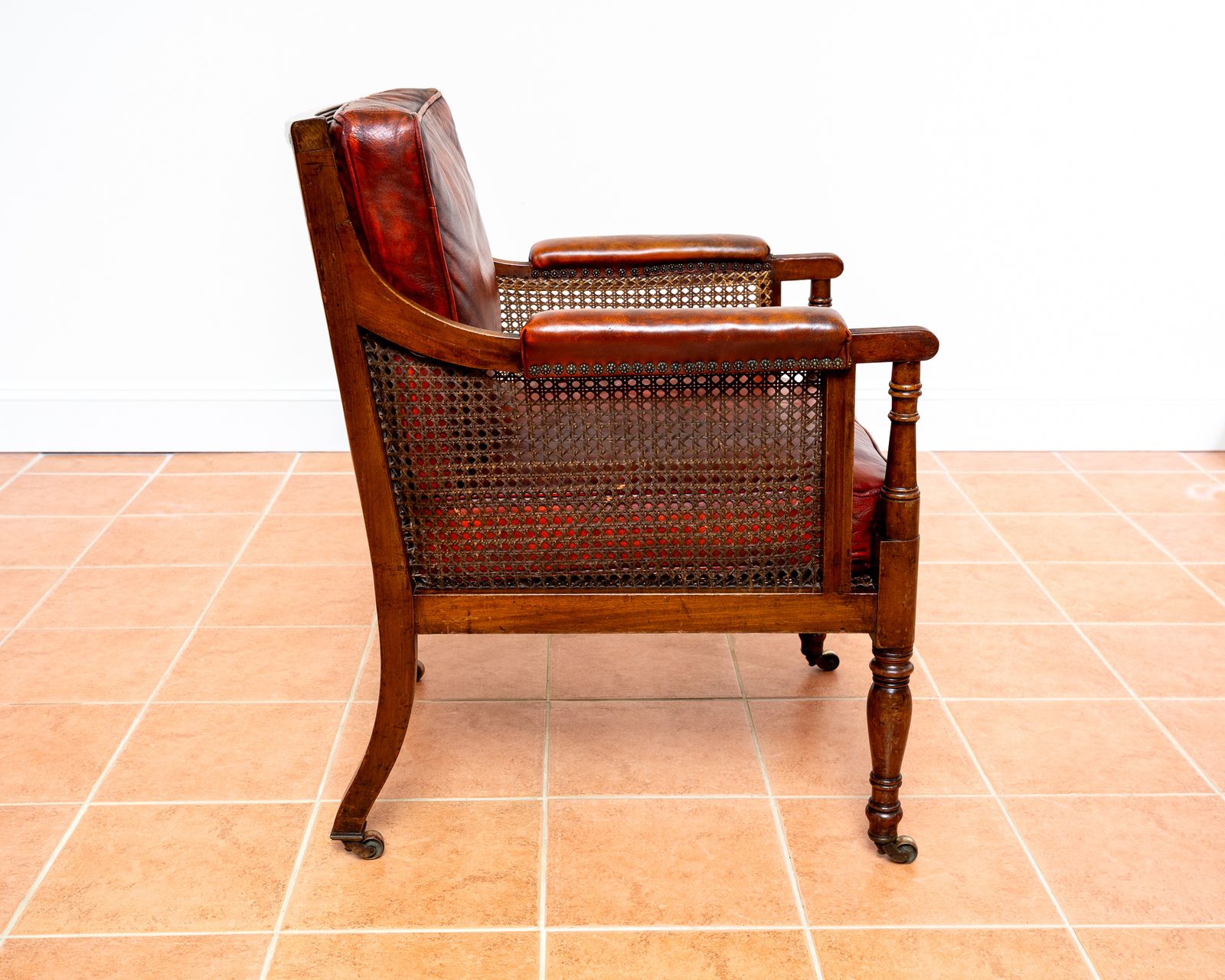 photo furniture Fine Regency Bergere Leather Library Chair 1810 1820 Georgian Reading Red Leather Armchair Carved Cane Rattan Brass Castors