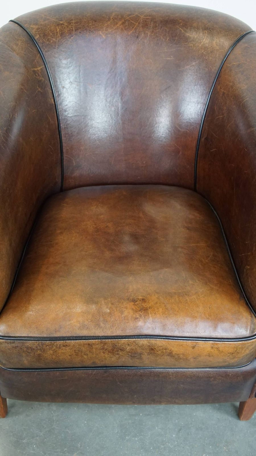 Dark And Sleek, Luxurious Sheepskin Club Chair With Beautiful Colours And A Black Piping Finish photo vinterior