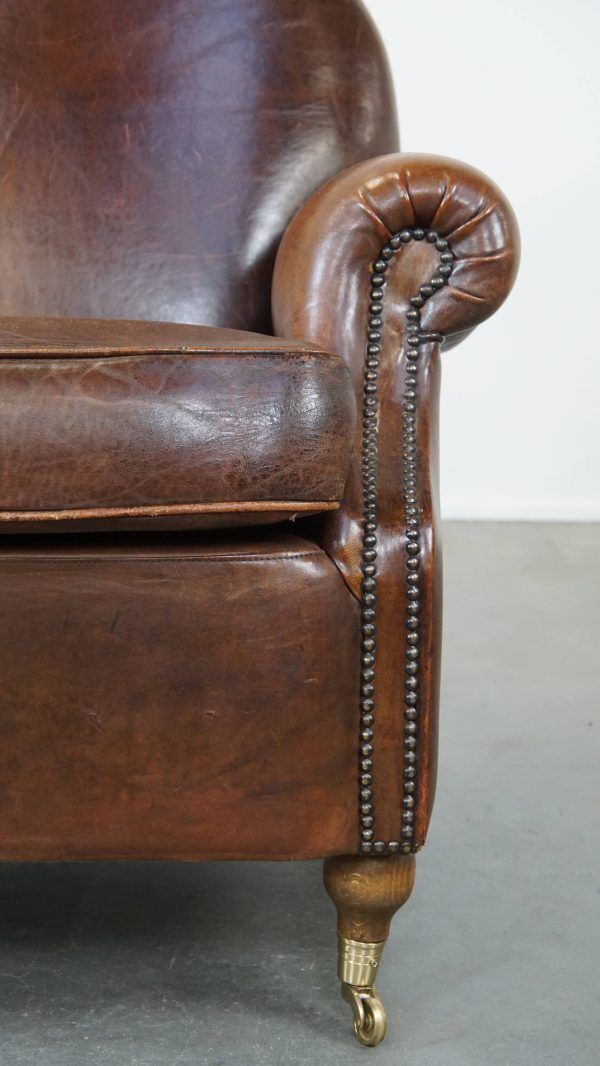 Klassieke Schapenvacht Fauteuil In Donkere Kleur, Goede Staat, Met Ronde Vormen En Op Wieltjes photo vintage