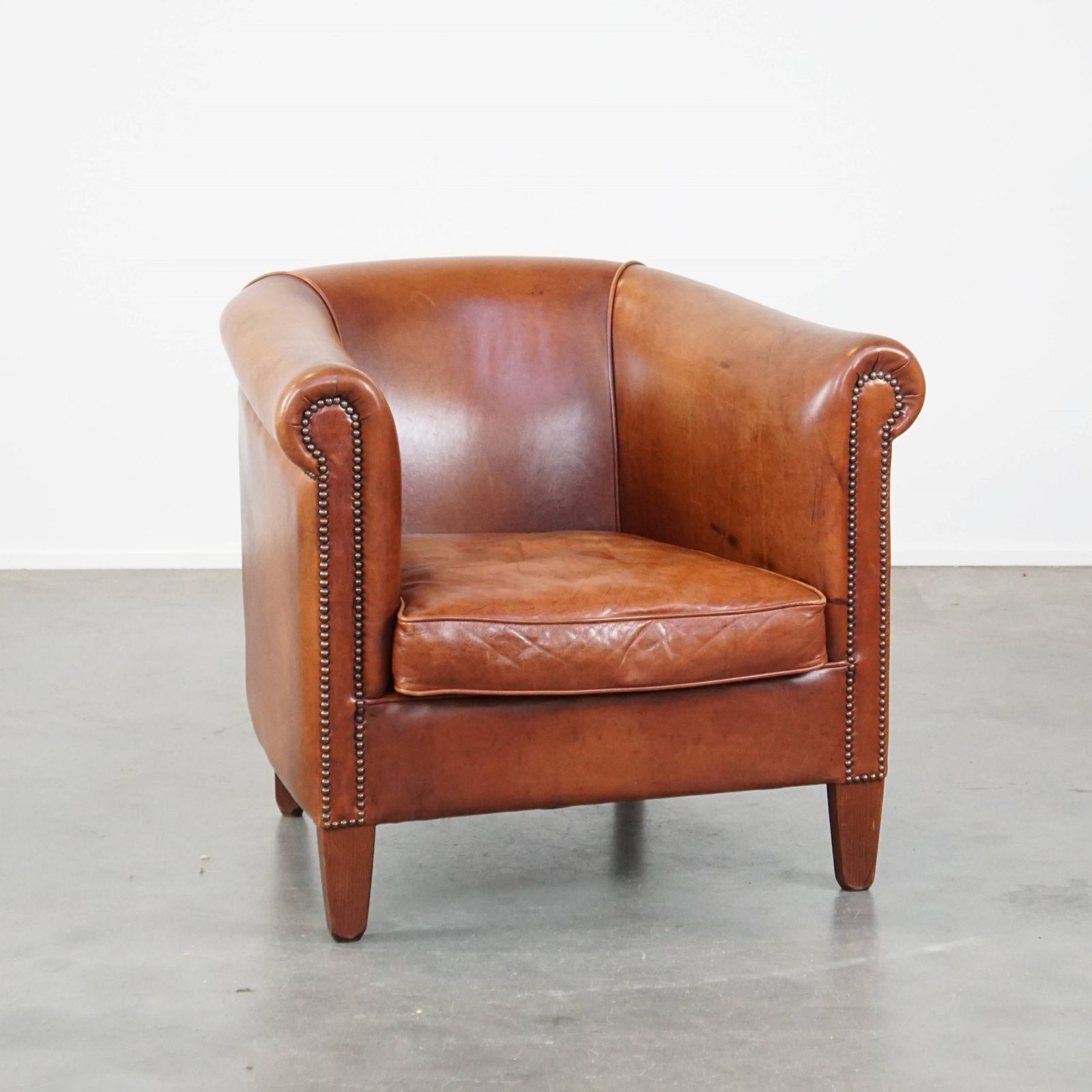 Comfortabele Cognackleurige Koeienhuid Club Chair Met Decoratieve Siernagels In Engelse Stijl