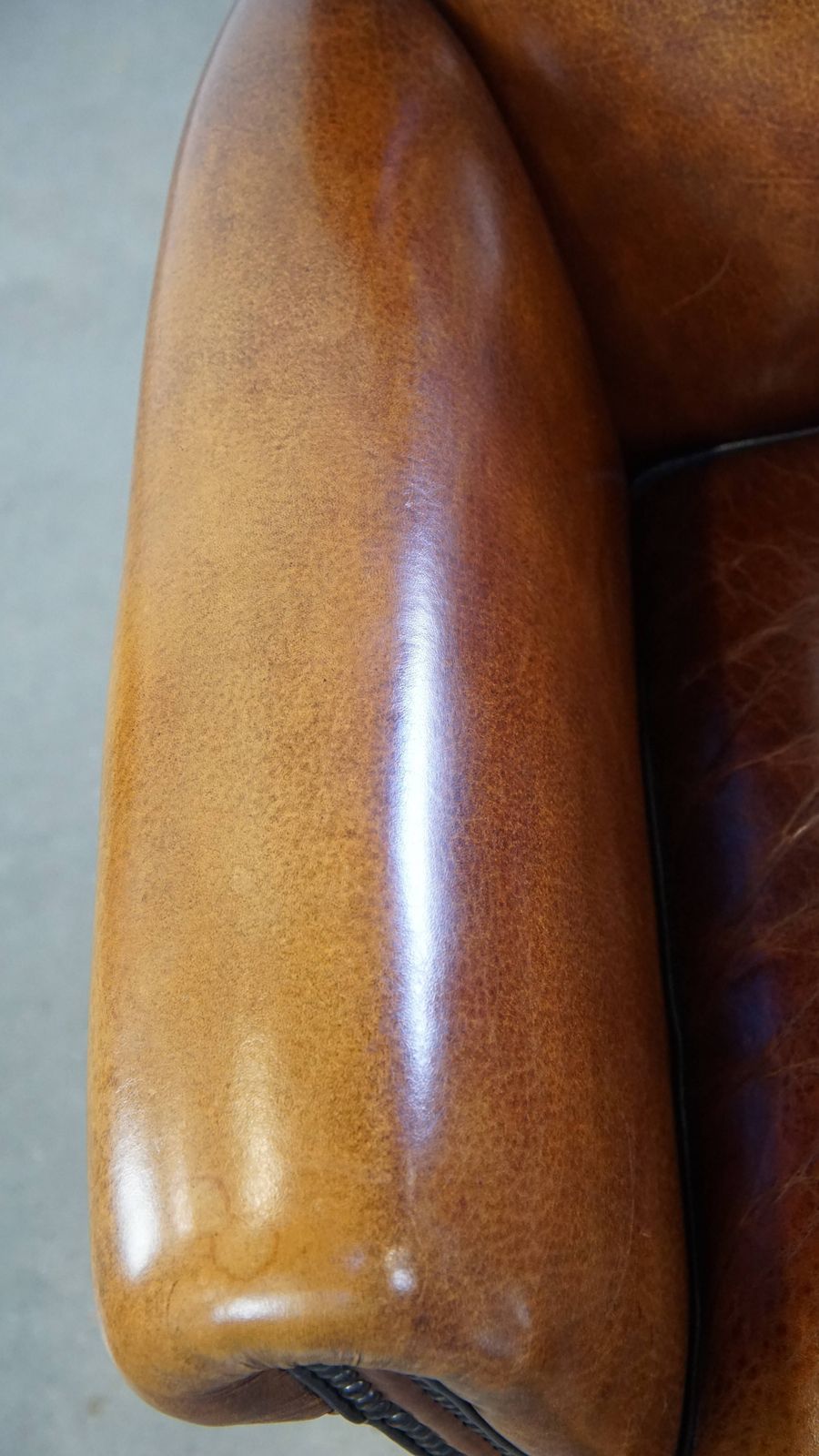 Goed onderhouden schapenleren design fauteuil, luxueus afgewerkt met siernagels en zwart biesje photo vintage