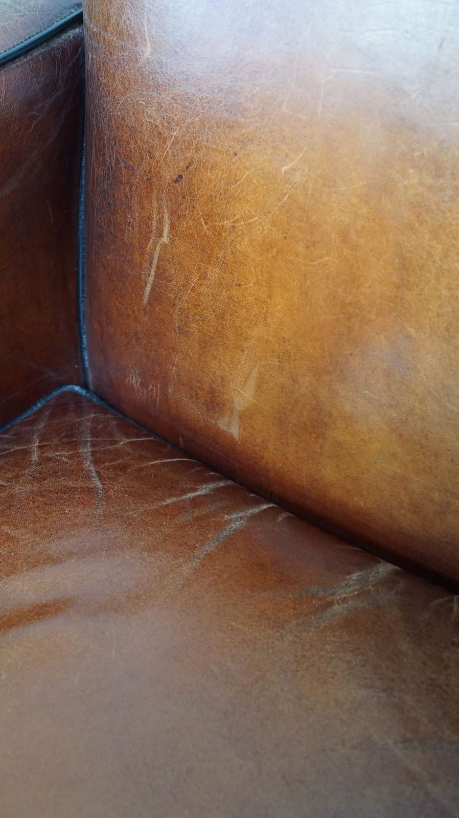 photo vinterior Fauteuil in Art Deco-stijl van schapenvacht met houten details en cognackleurig leer
