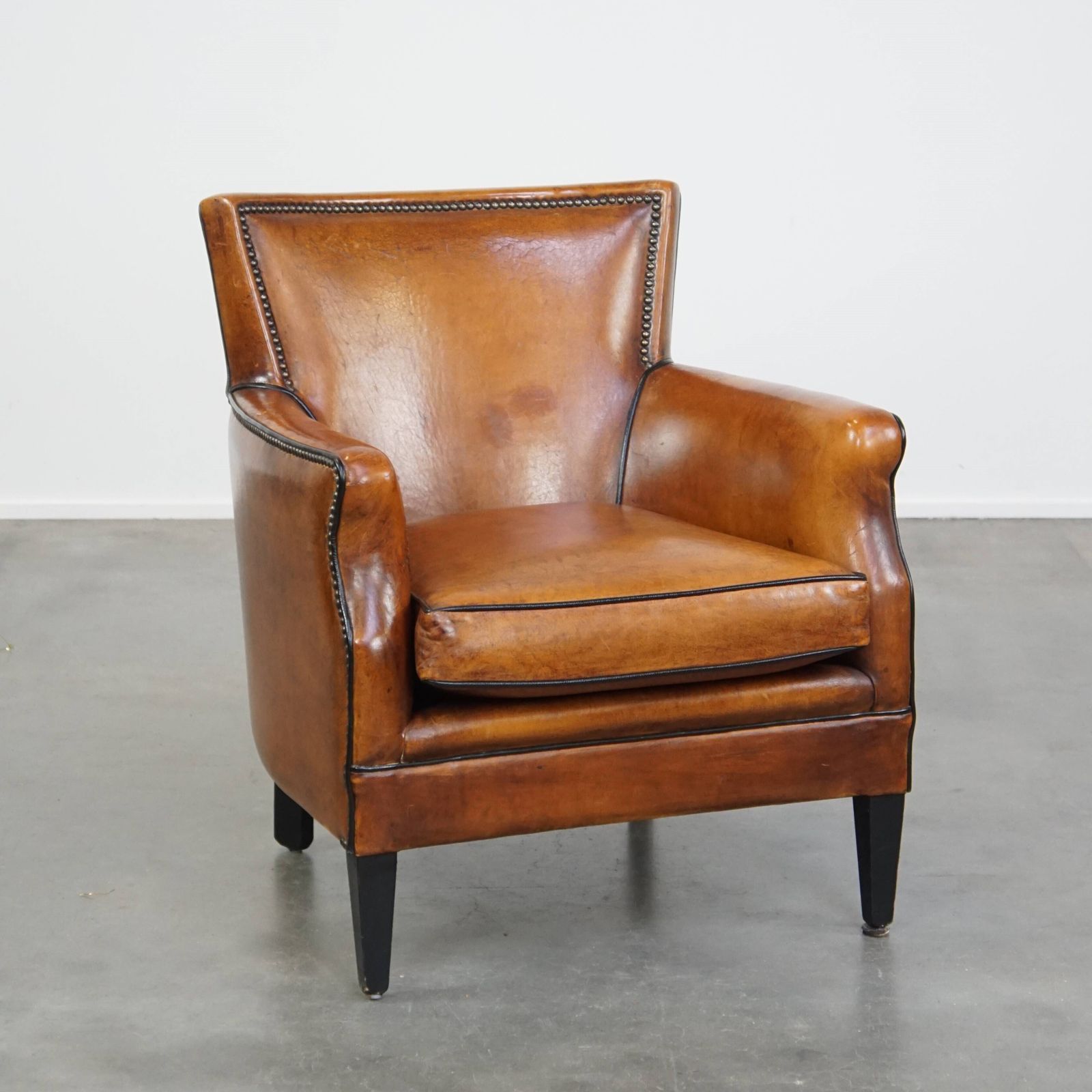Subtle Cognac Colored Sheepskin Armchair With A Nice Design And Finish With Black Piping And Decorative Nails