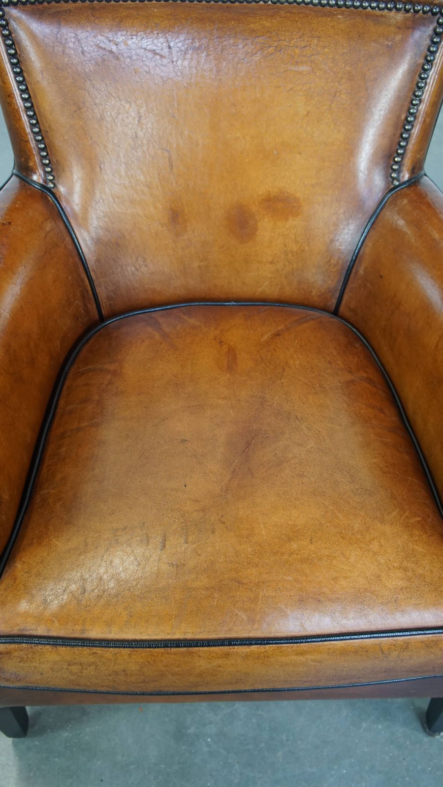 Subtle Cognac Colored Sheepskin Armchair With A Nice Design And Finish With Black Piping And Decorative Nails photo vinterior
