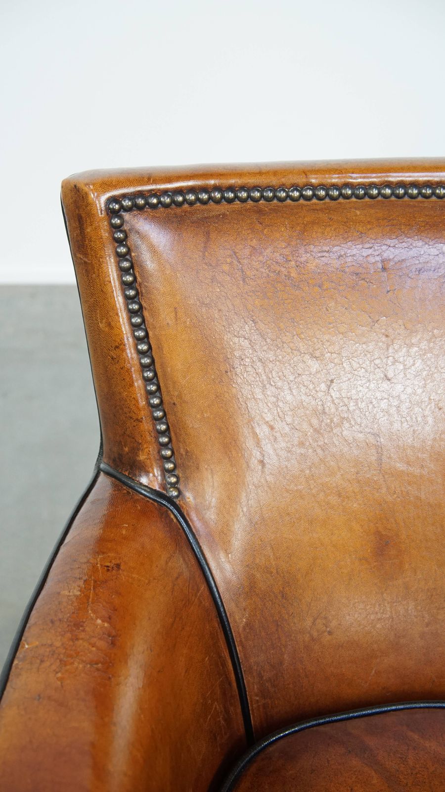 photo furniture Subtle Cognac Colored Sheepskin Armchair With A Nice Design And Finish With Black Piping And Decorative Nails