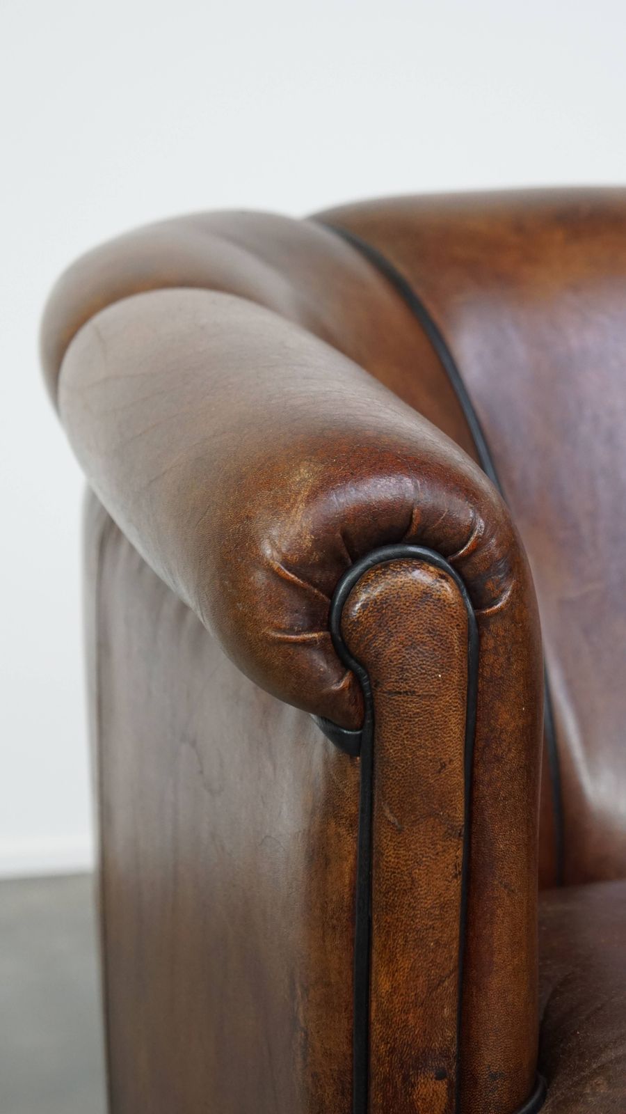 photo for sale Bijzondere En Statige Clubfauteuil Van Donker Schapenleer Met Zwarte Paspelafwerking