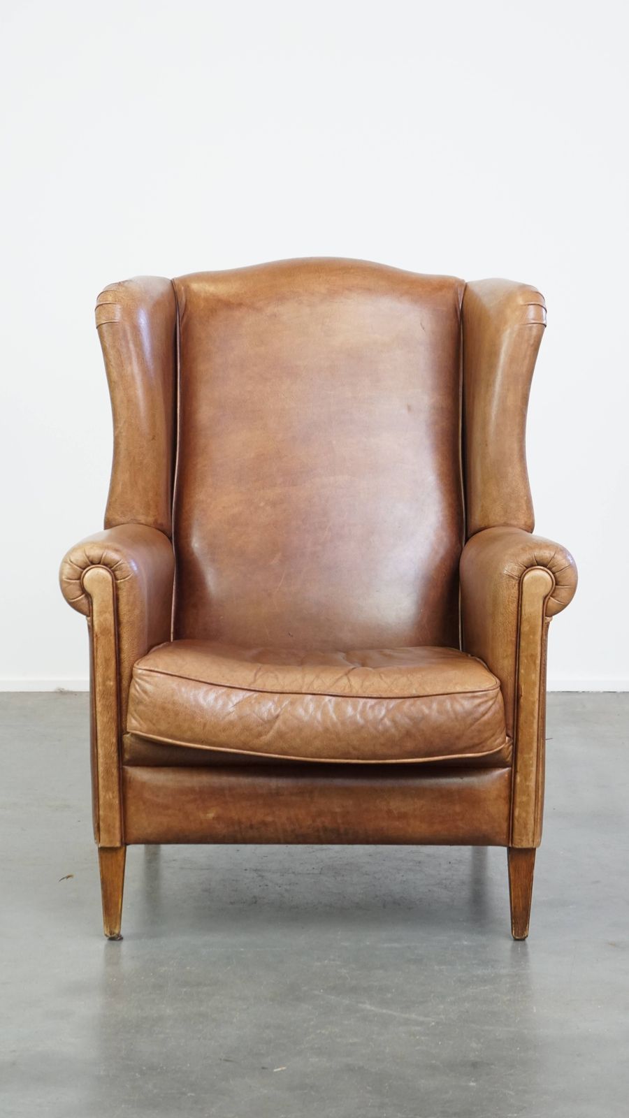 Charming, Timeless And Characterful Cowhide Wing Chair In A Light Cognac Color Finished With A Matching Piping photo furniture