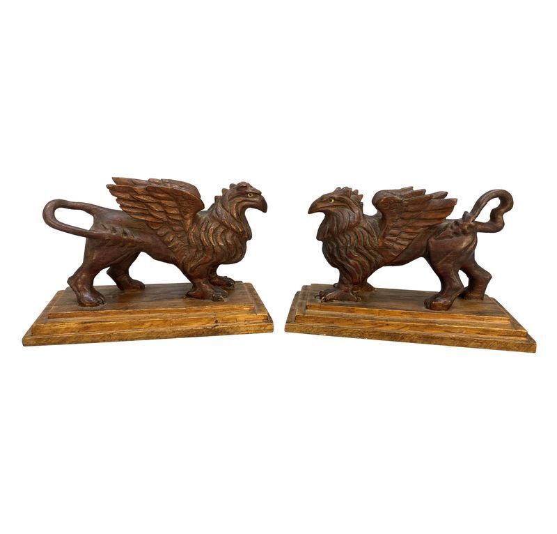 A Pair Of Carved Griffins On Plinths