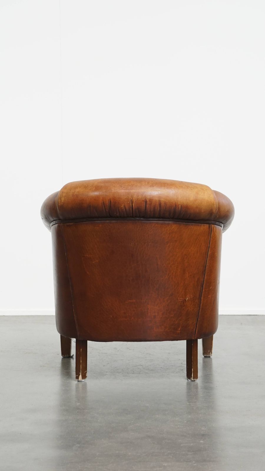 Stevige, Tijdloze Clubfauteuil In Cognackleurig Schapenleer Met Een Uitgesproken Vintage Uitstraling photo Meubels
