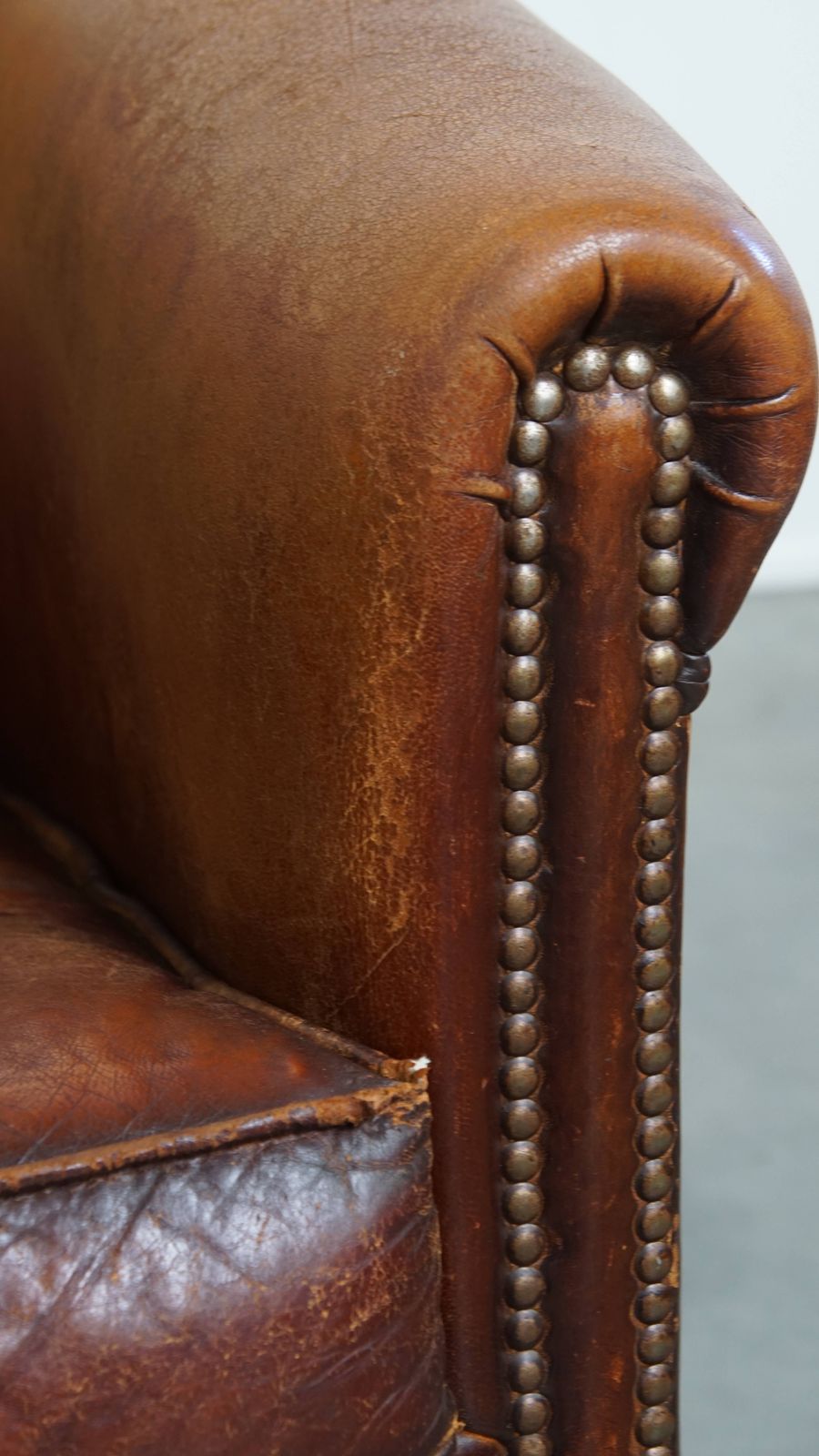photo vintage Stevige, Tijdloze Clubfauteuil In Cognackleurig Schapenleer Met Een Uitgesproken Vintage Uitstraling