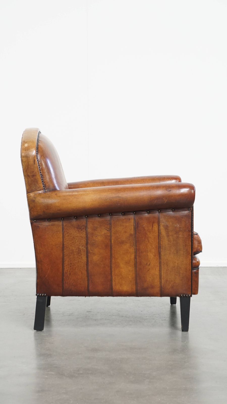 Stylish Sheepskin Designer Armchair In A Warm Cognac Color With A Finish Of Black Piping And Decorative Studs photo for sale