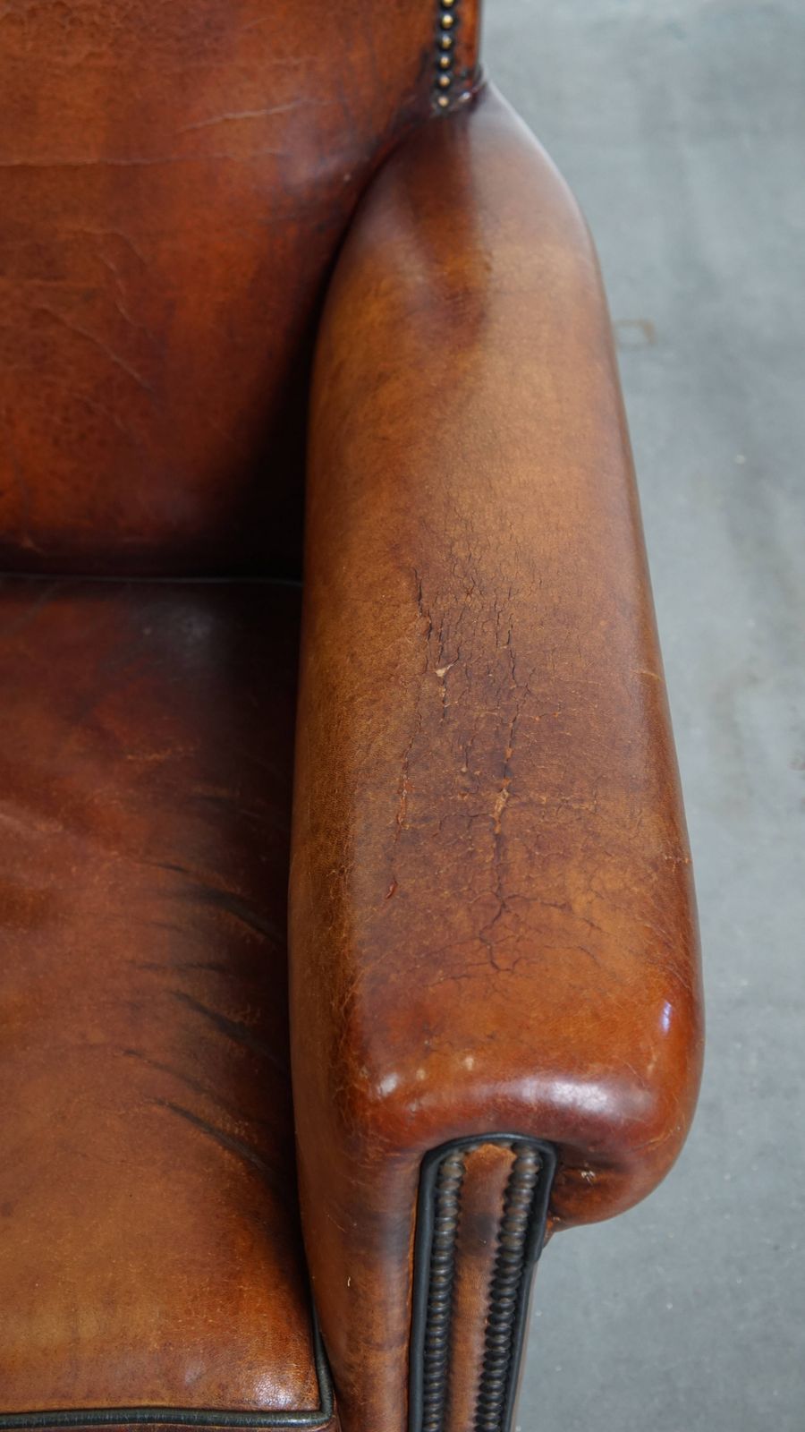 Stylish Sheepskin Designer Armchair In A Warm Cognac Color With A Finish Of Black Piping And Decorative Studs photo vintage