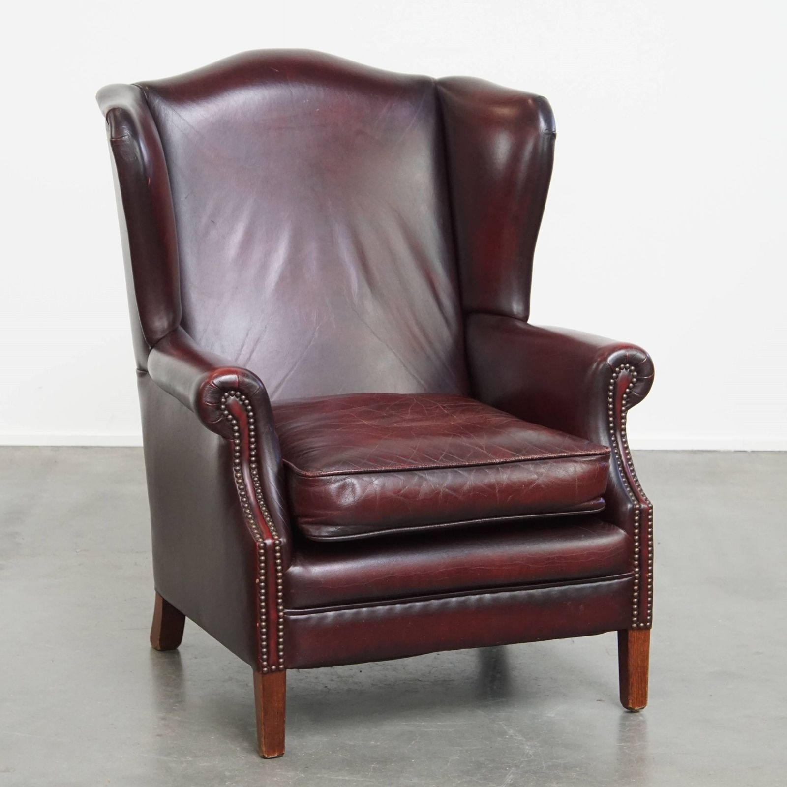 Charming And Comfortable Burgundy Red Cowhide Wing Chair In English Style With A Beautiful Patina