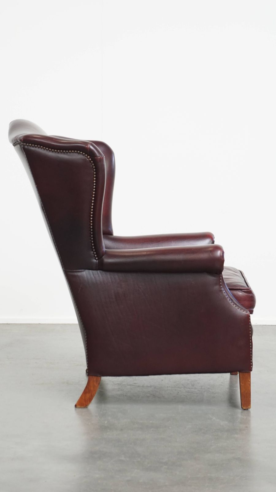 Beautiful And Comfortable Burgundy Red Cowhide Wing Chair In English Style With A Wonderful Patina photo for sale