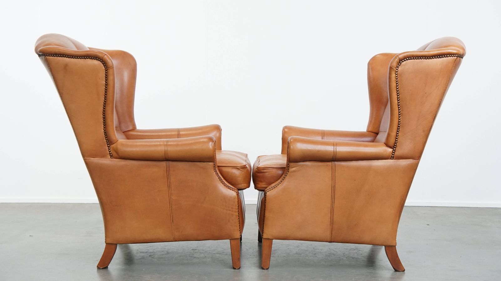 Classic And Unique Set Of 2 Cowhide Wing Chairs Finished With Decorative Nails And Beautiful Details photo furniture