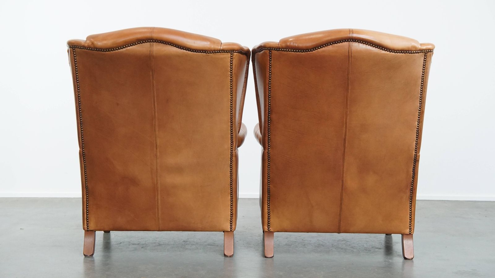 Classic And Unique Set Of 2 Cowhide Wing Chairs Finished With Decorative Nails And Beautiful Details photo for sale