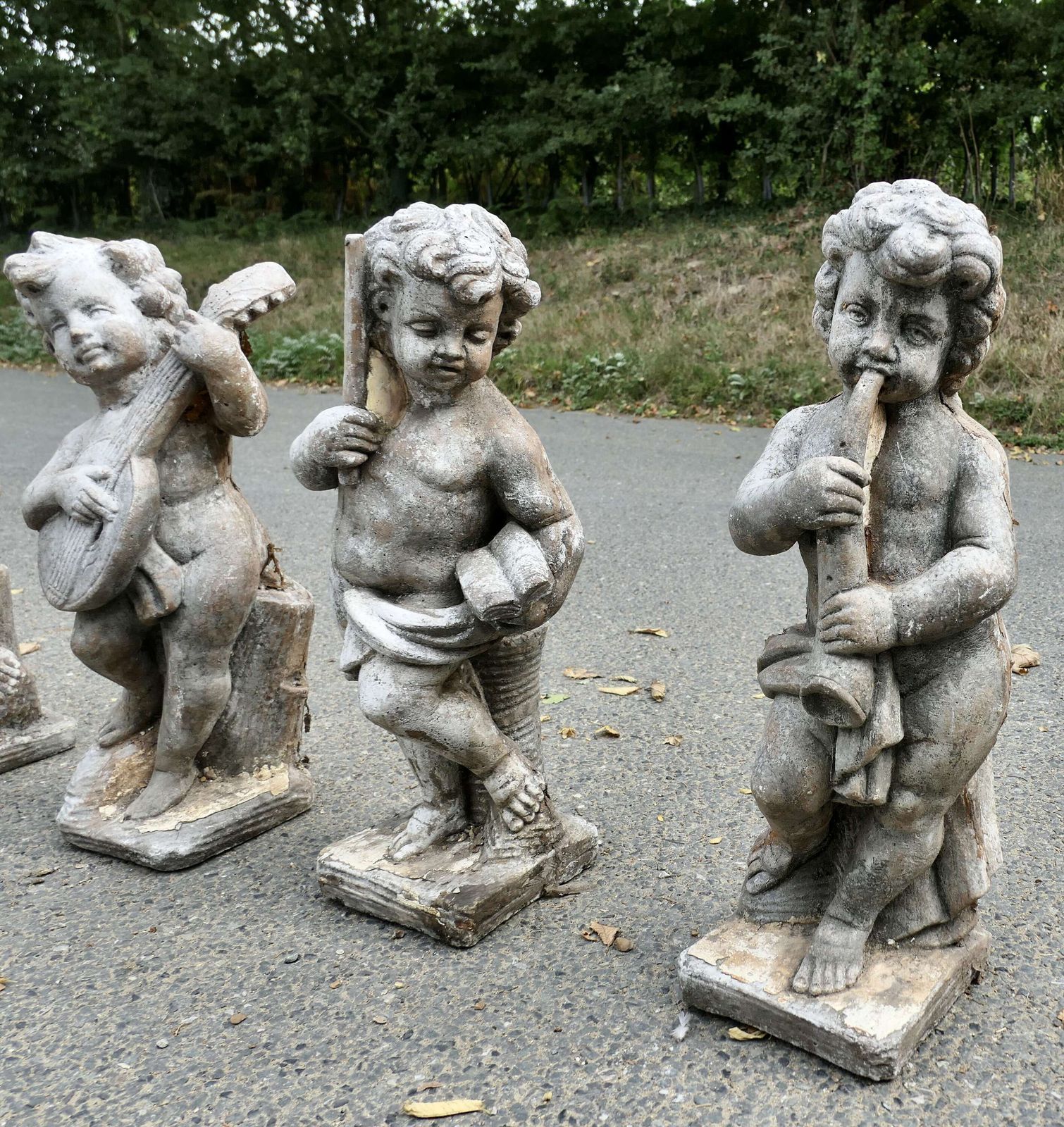 A Set Of 4 Weather Worn Cherub Statues With Instruments photo 3000.0
