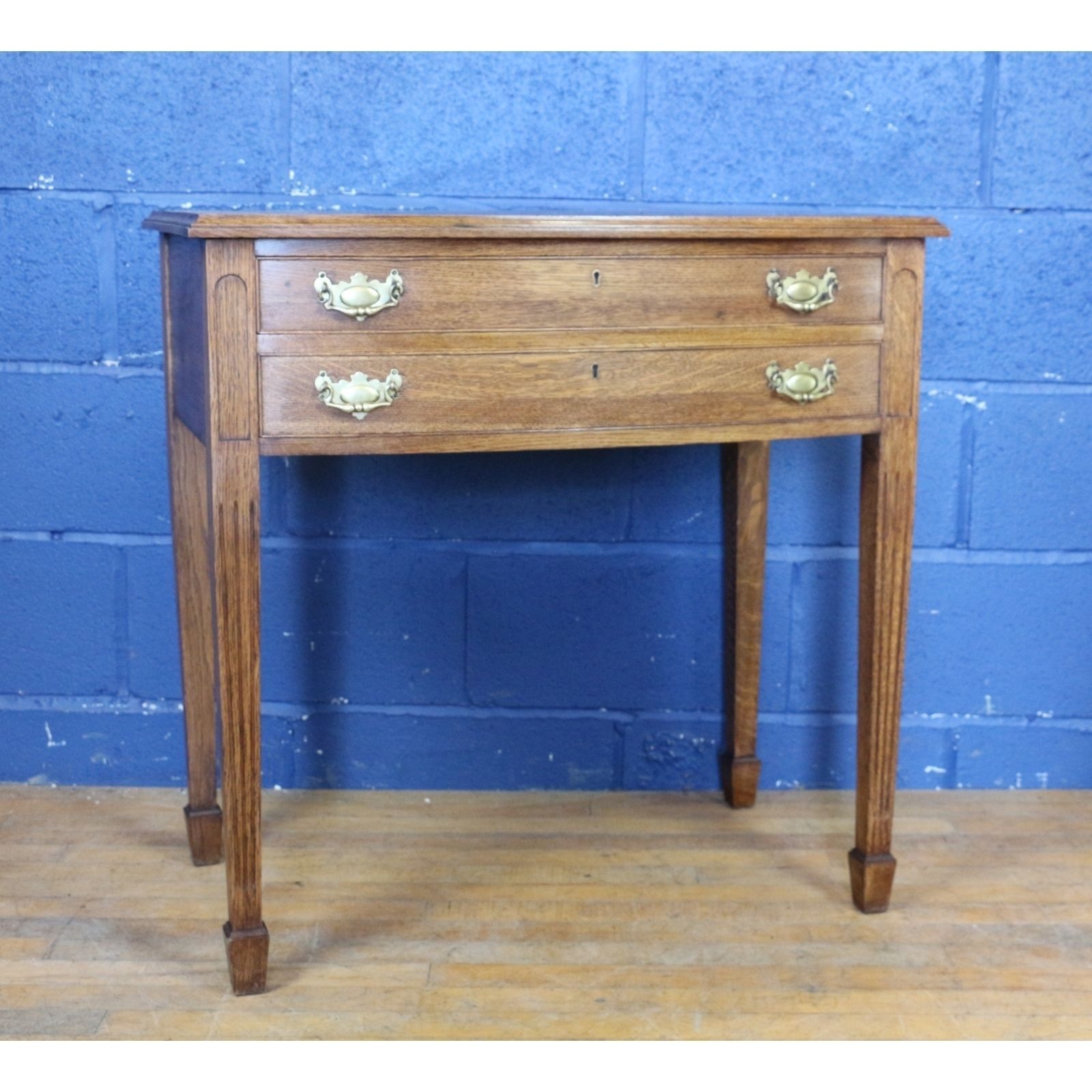 A Quality Oak Bow Fronted Two Drawer Side Table Raised On Tapering Spade Feet