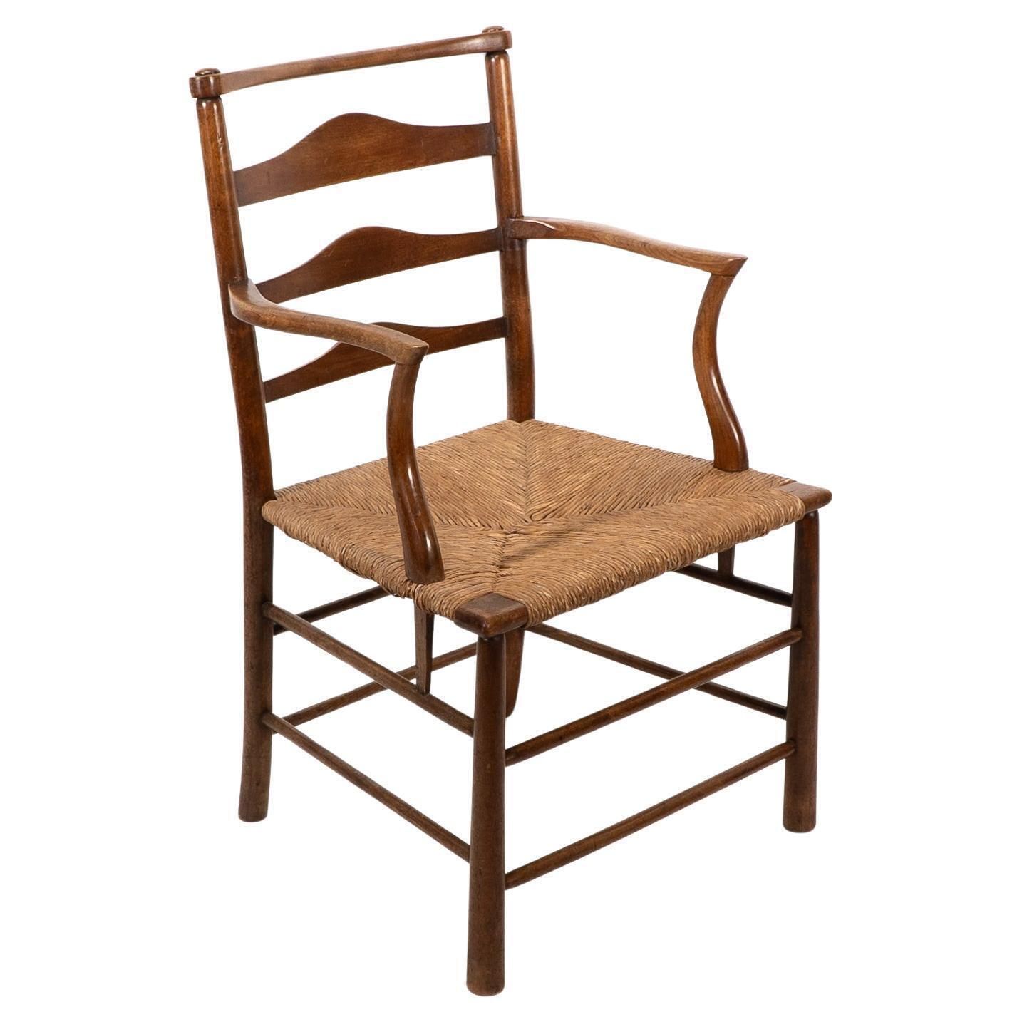 C R Ashbee. An Arts And Crafts Rush Seat Ladder Back Armchair