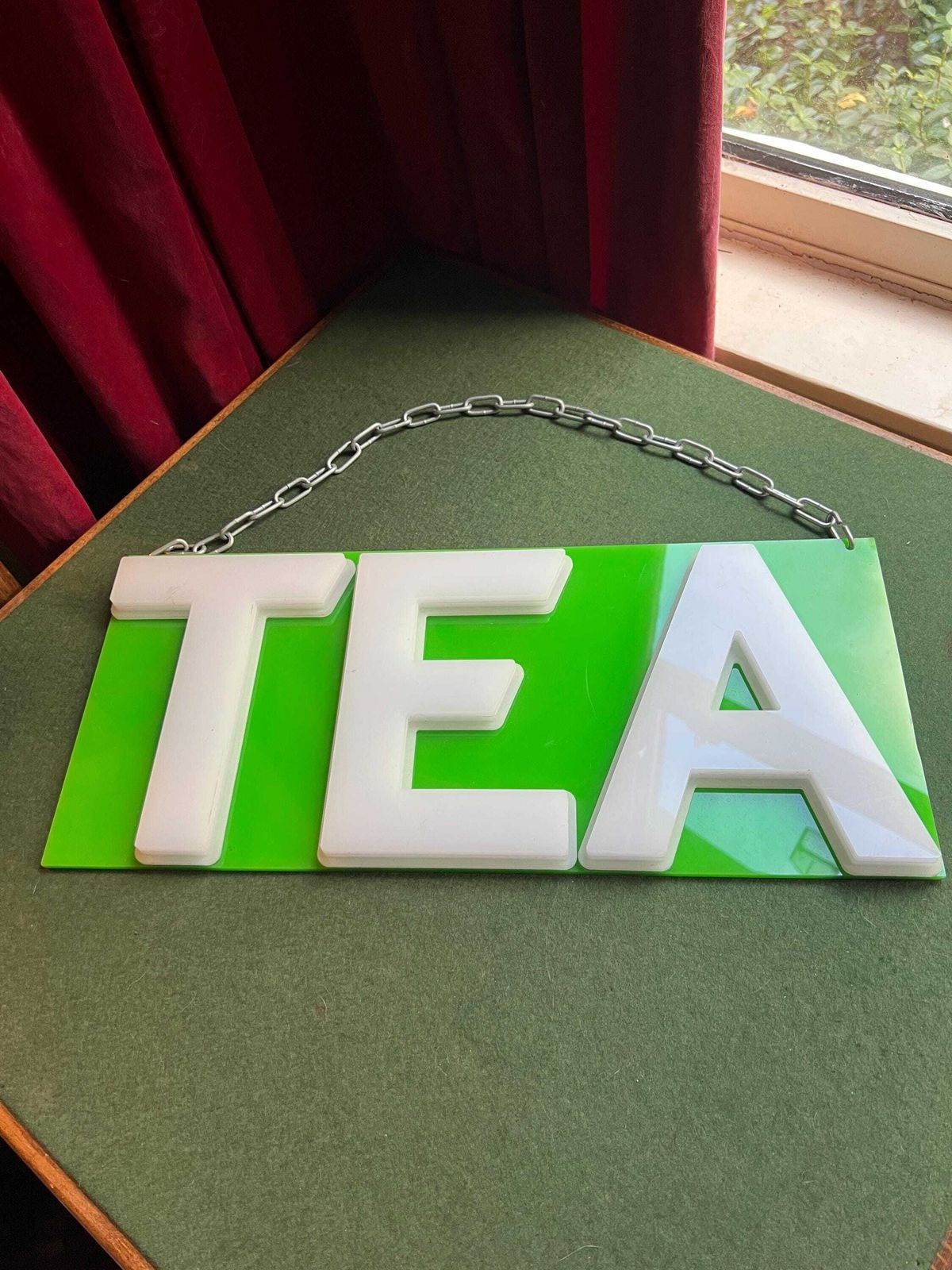 Vintage Plastic Tea Sign. White Plastic Letters On Neon Green Background. Silver Metal Hanging Chain. photo vinterior