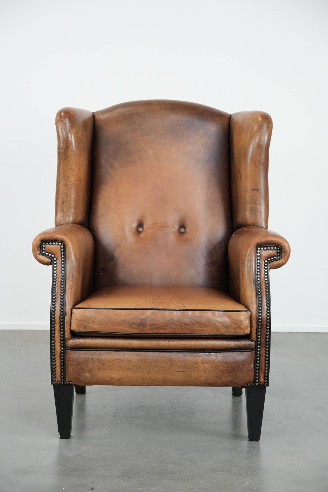 Large And Comfortable Sheepskin Wing Chair With A Characterful Look With Black Piping And Decorative Studs photo furniture