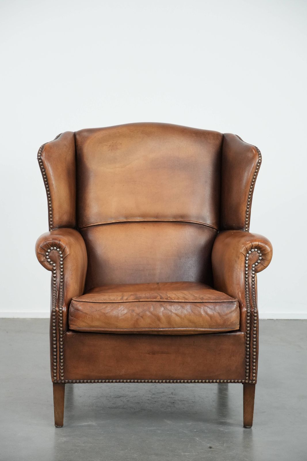 Charming Sheepskin Wing Chair With Warm Colours Finished With Decorative Studs photo furniture