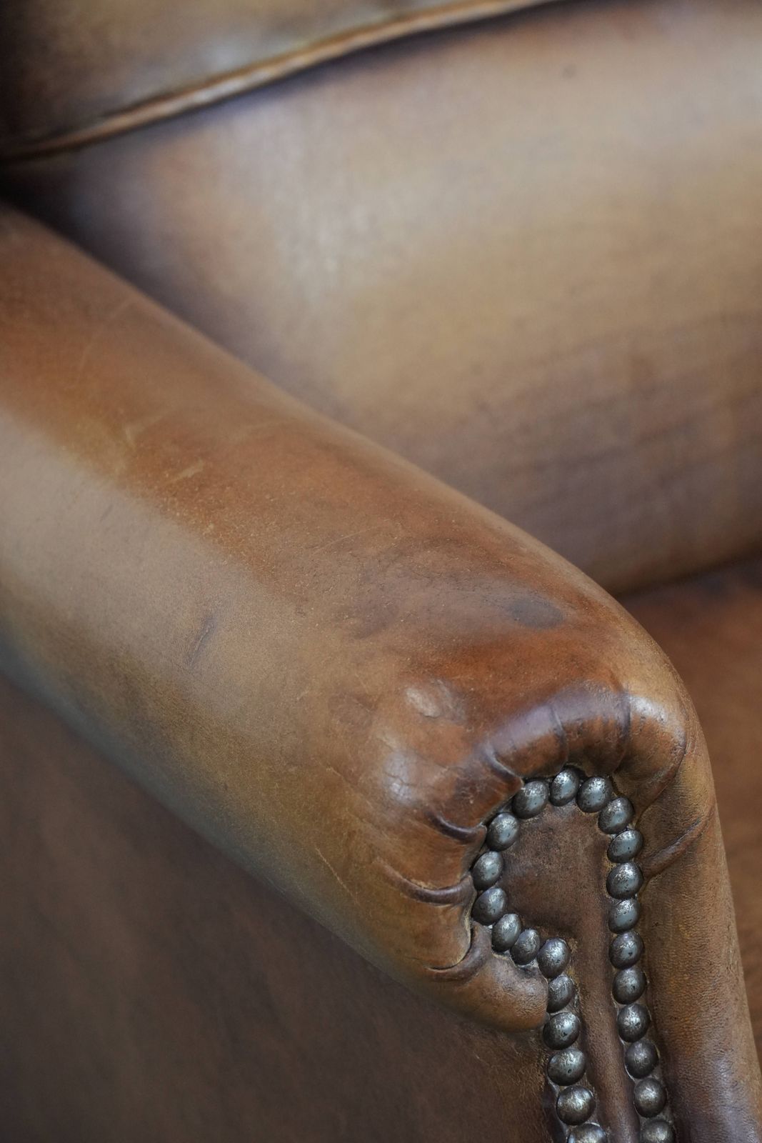 photo buy Charming Sheepskin Wing Chair With Warm Colours Finished With Decorative Studs