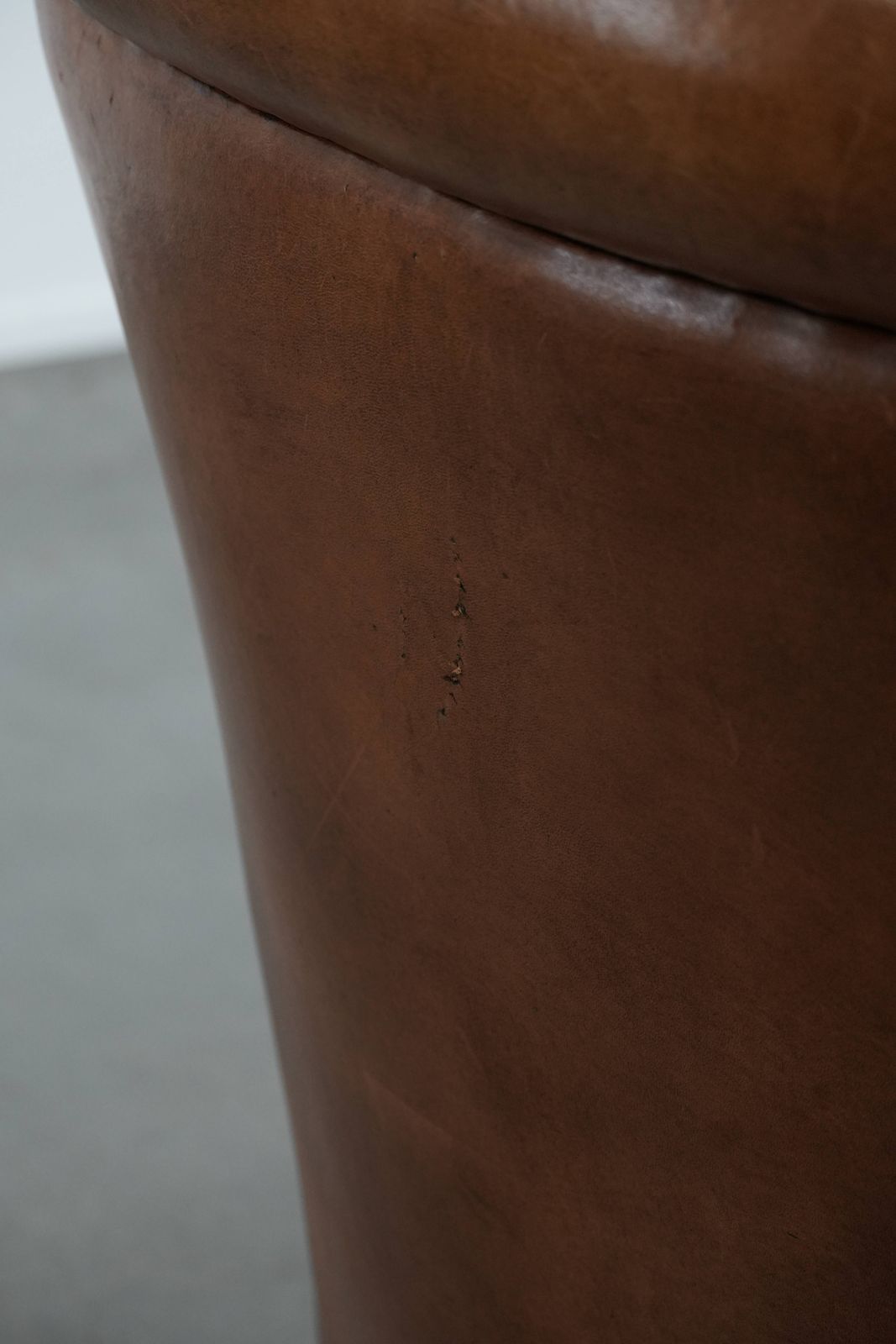 photo vinterior Karaktervolle Vintage Fauteuil Van Schapenleer Met Warme Kleuren