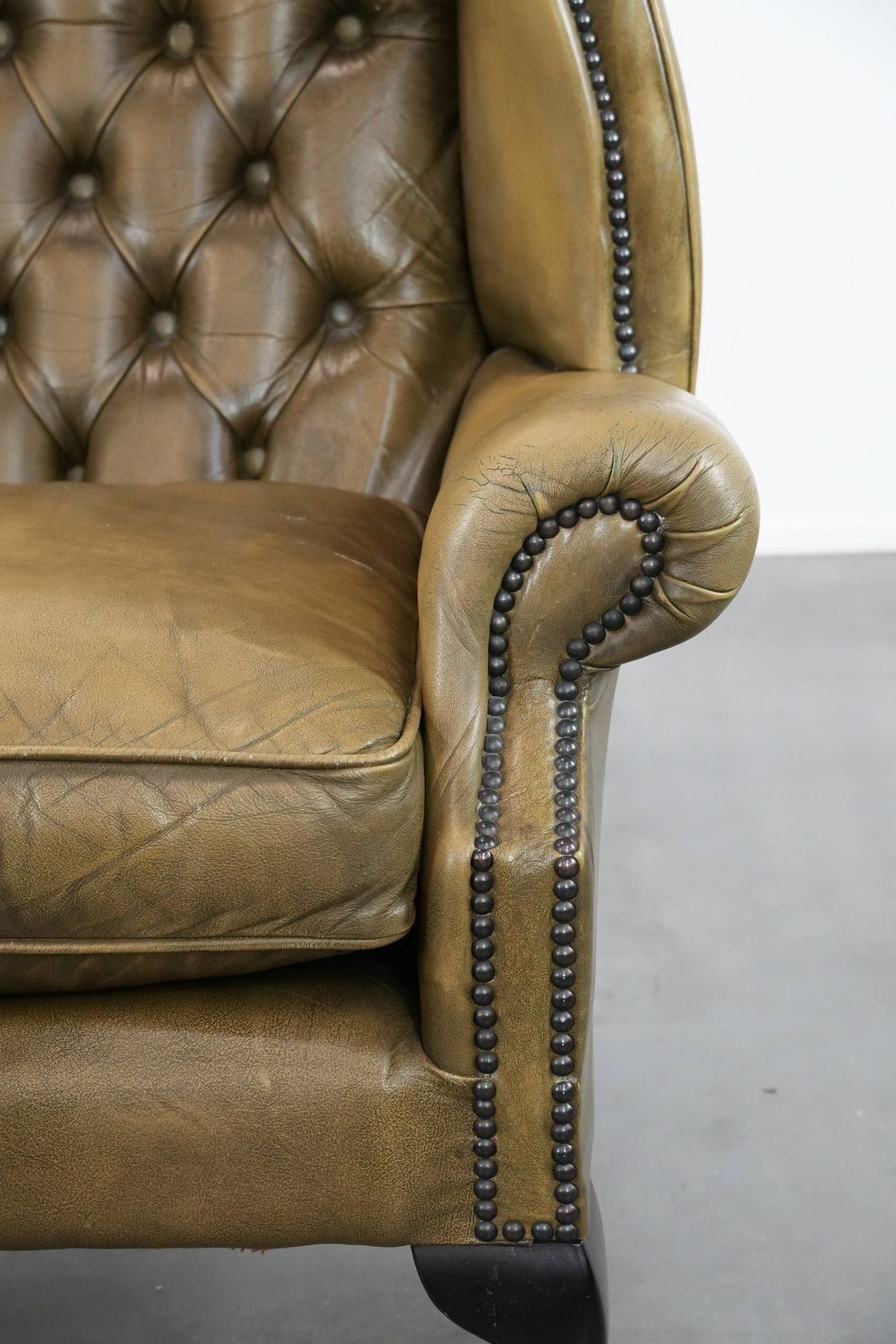 photo furniture Moss Green Cowhide Chesterfield Wingback Armchair In English Style Finished With Decorative Nails