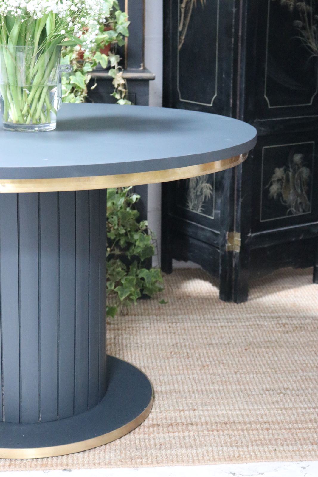 250.0 Stunning Black Round Dining Table With Brass Metal Edge Slatted Wood Column Base photo
