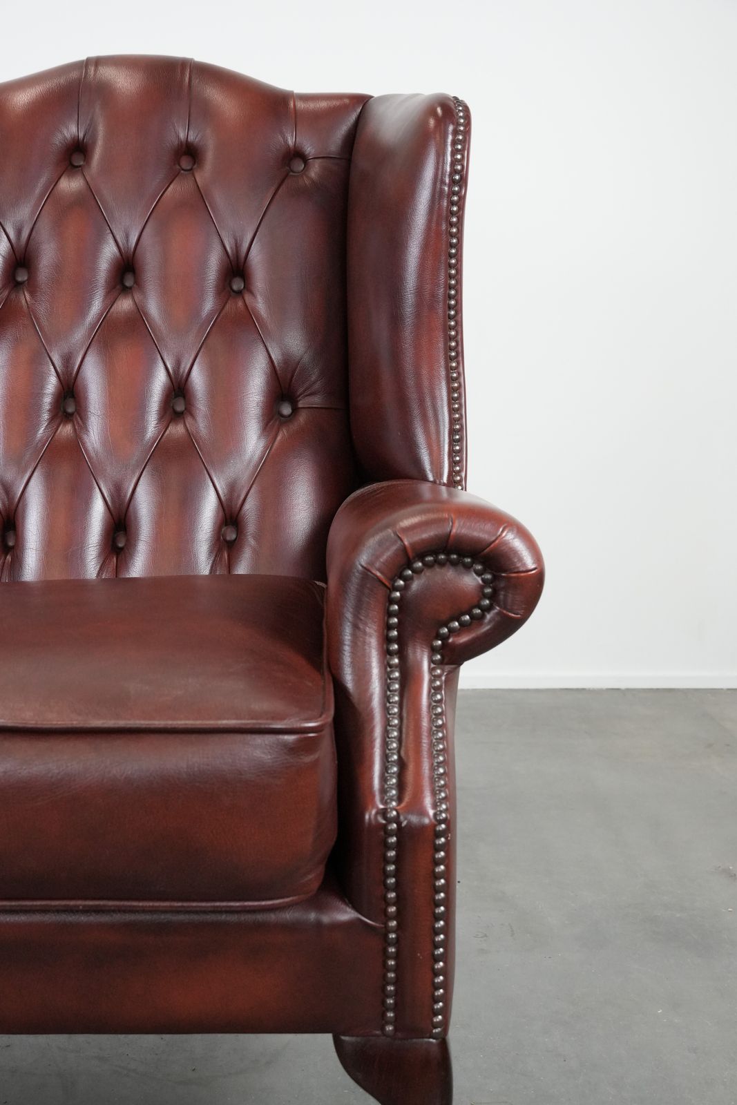 photo furniture Klassieke Engelse Chesterfield Fauteuil Met Vleugelleuningen In Koeienleer, In Een Prachtige Rode Kleur