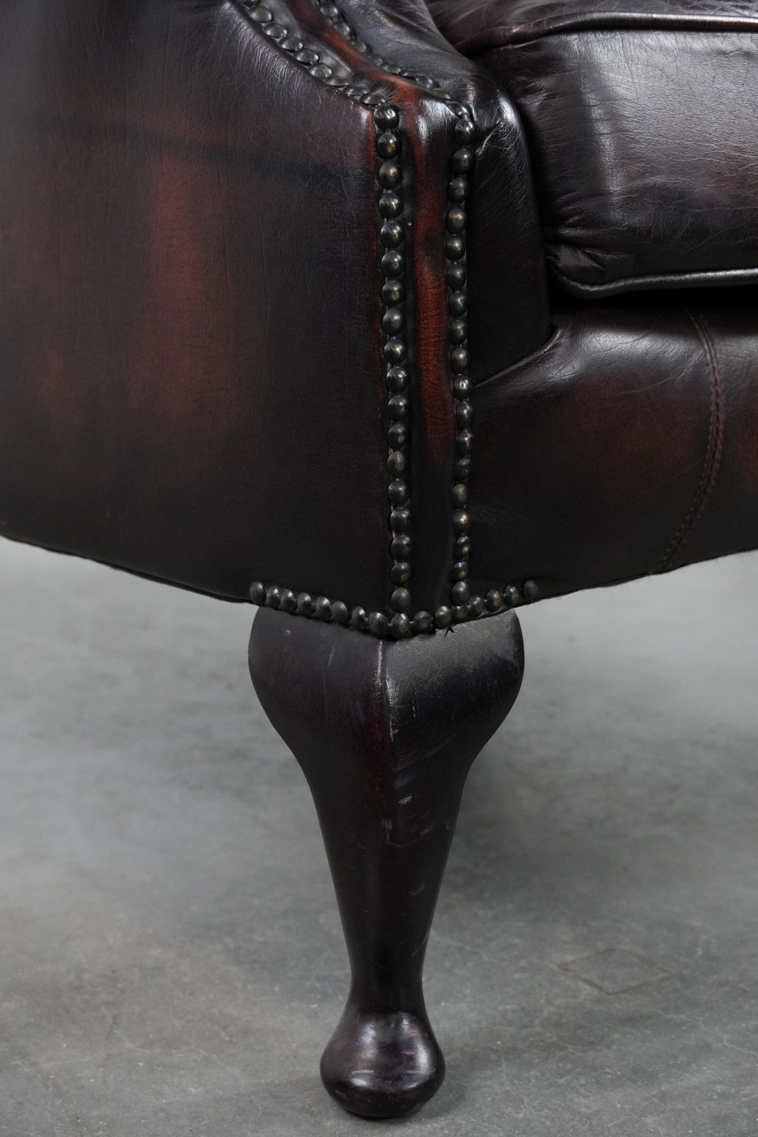 Furniture Beautiful, Luxurious, And Comfortable Brown Cowhide Chesterfield Wing Armchair In A Classic English Style. photo