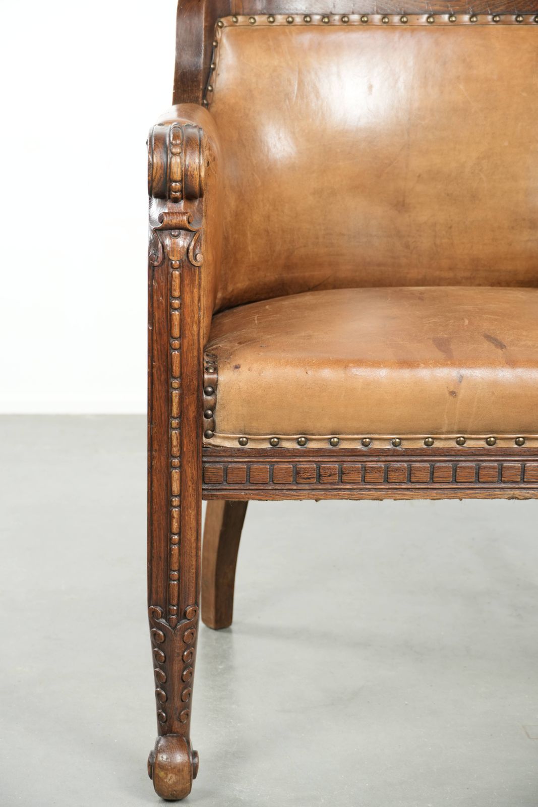 photo furniture Antique Armchair Of Sheepskin And Wood With Decorative Nails And Beautiful Woodwork
