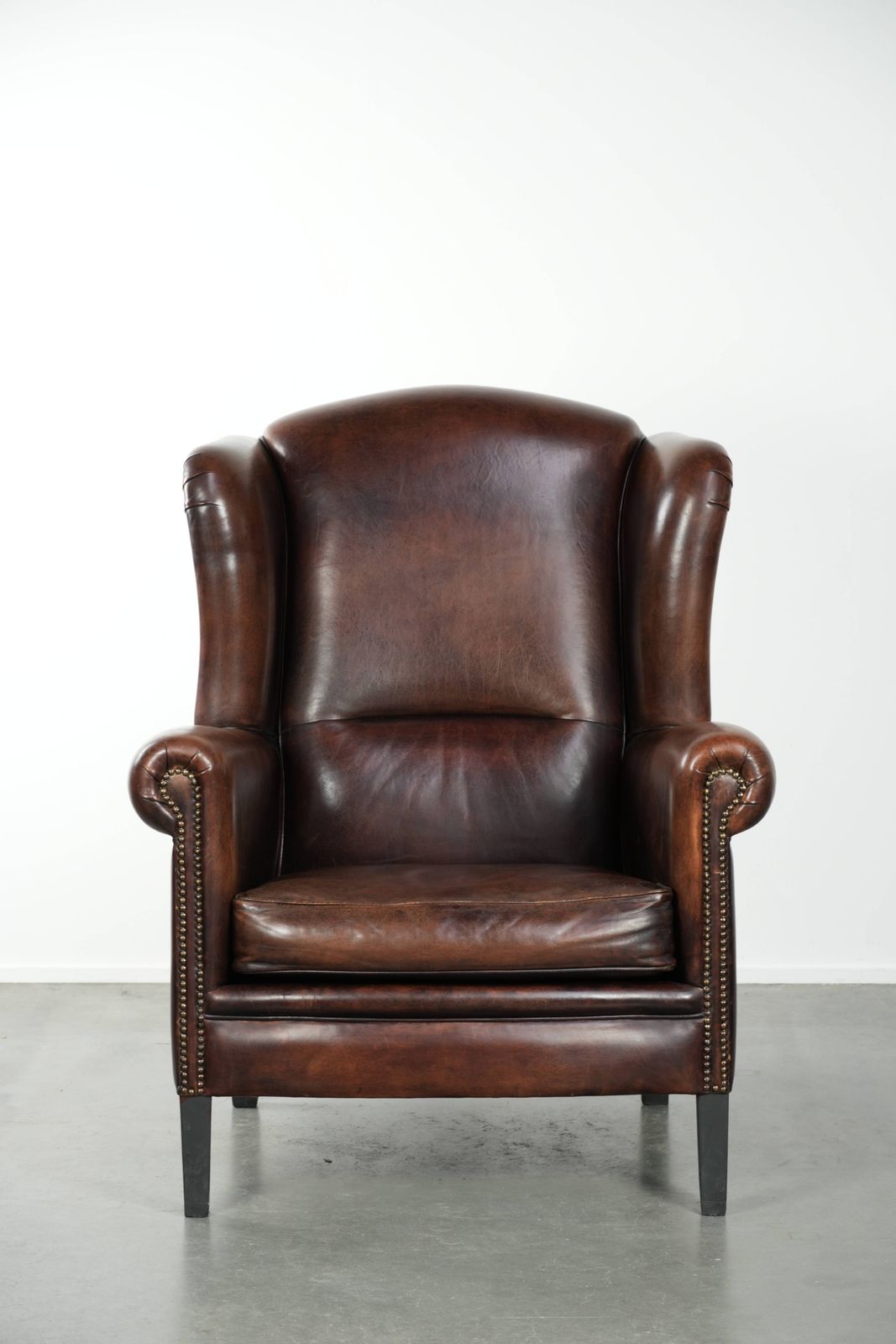 Beautiful Large And Comfortable Sheepskin Wing Armchair With Lovely Deep And Warm Colors And A Finish With Decorative Nails. photo furniture