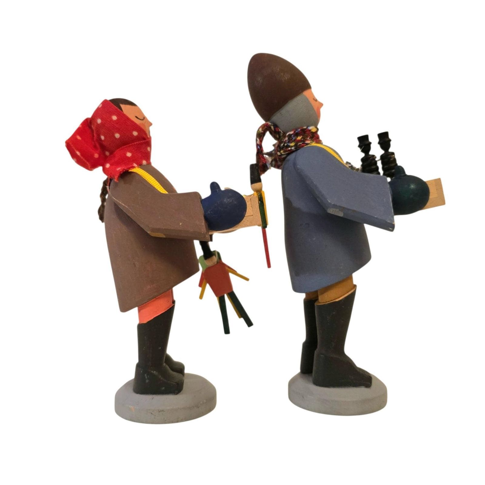 Figurines en bois traditionnelles de l'Erzgebirge représentant une paire d'enfants colporteurs de jouets. Sculptées à la main en Allemagne. photo vinterior