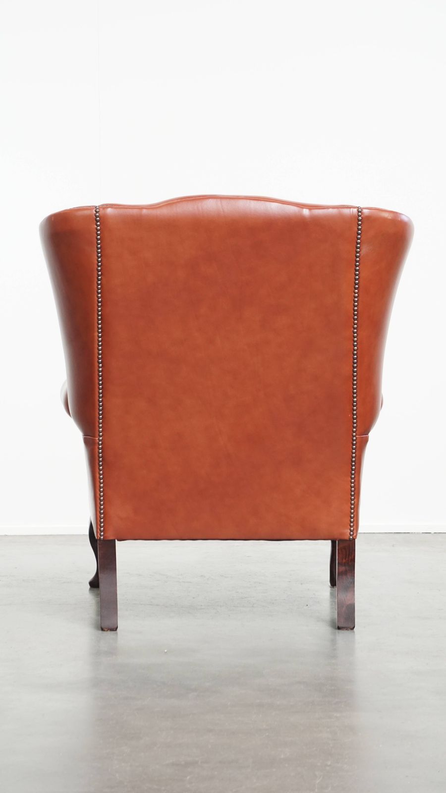 Elegante En Comfortabele Chesterfield Vleugelfauteuil In Glad Engelse Koeienhuid Met Sierlijke Poten photo Meubels