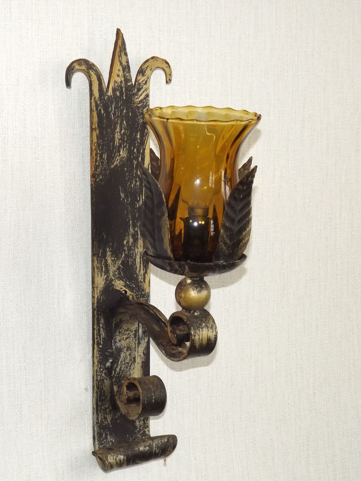 Paar handgesmede smeedijzeren wandlampen in middeleeuwse stijl met amberkleurige glazen kappen photo buy