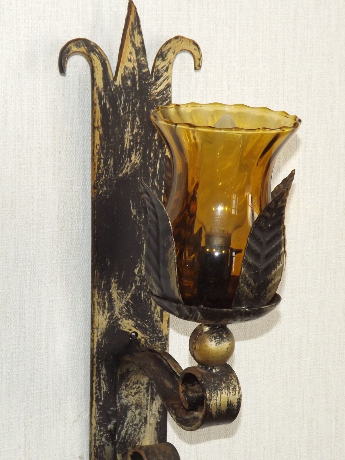 photo furniture Paar handgesmede smeedijzeren wandlampen in middeleeuwse stijl met amberkleurige glazen kappen
