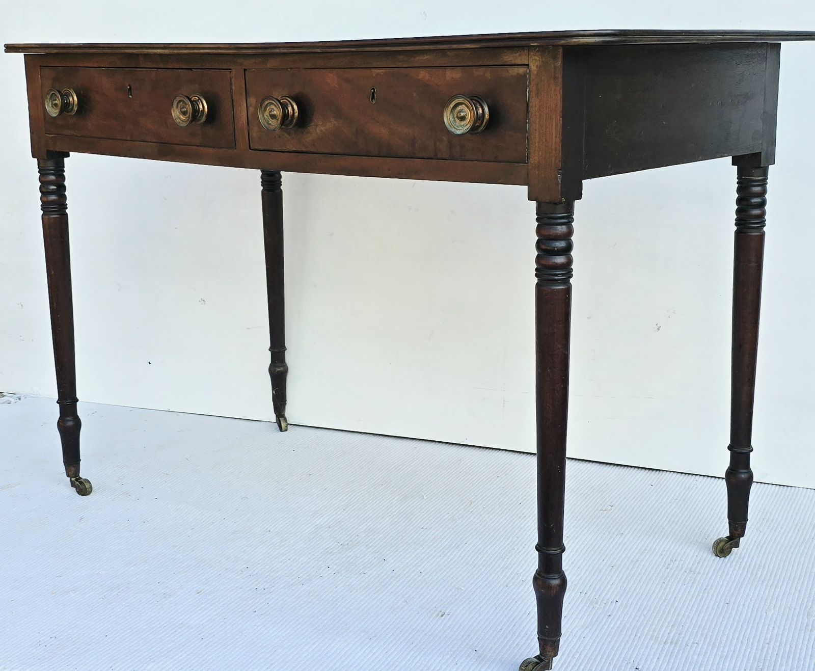 An Antique Regency Mahogany Writing Desk On Castors. photo for sale