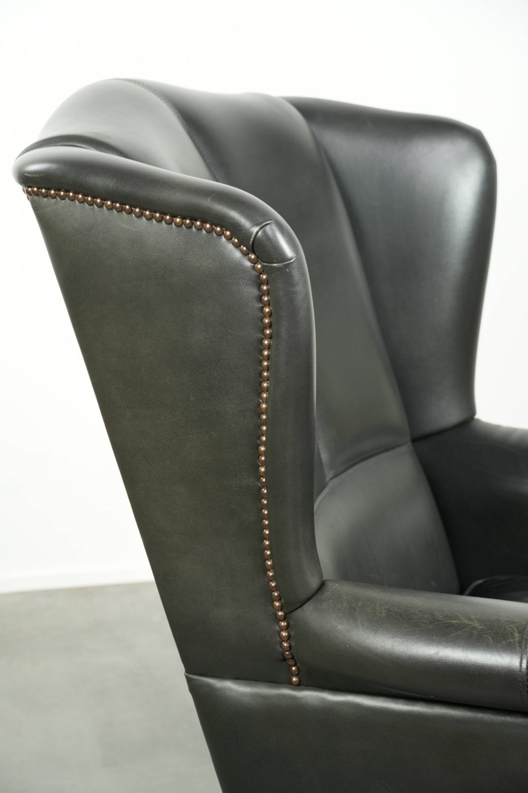 photo buy Black Cowhide Wing Armchair In A Classic English Style, Finished With Decorative Nails.